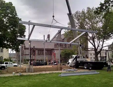 Crane lifting a fabricated steel roof frame onto a park pavilion in Illinois