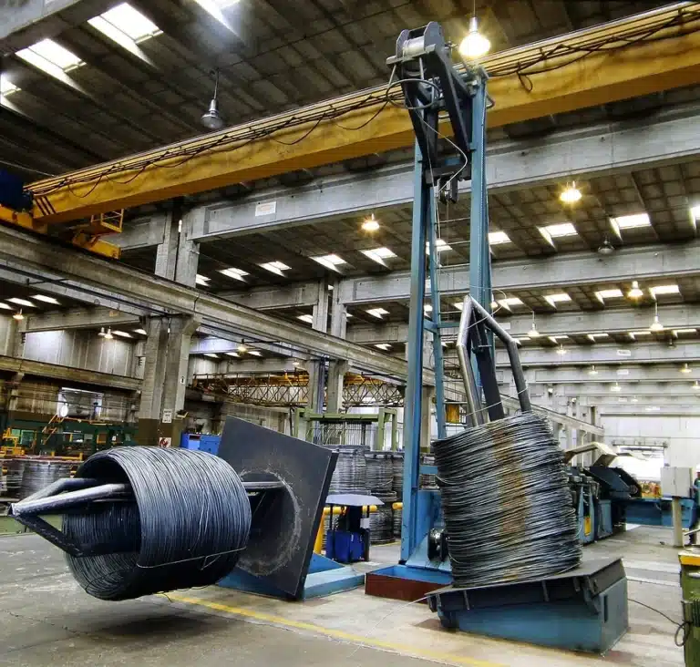Overhead crane moving steel wire coils in a material handling facility in Michigan