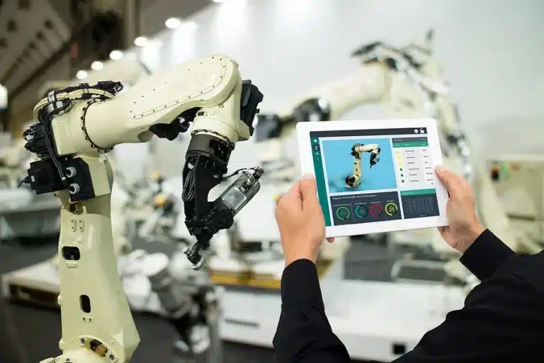 Technician controlling an industrial robot arm from a tablet - automation fabrication in Michigan