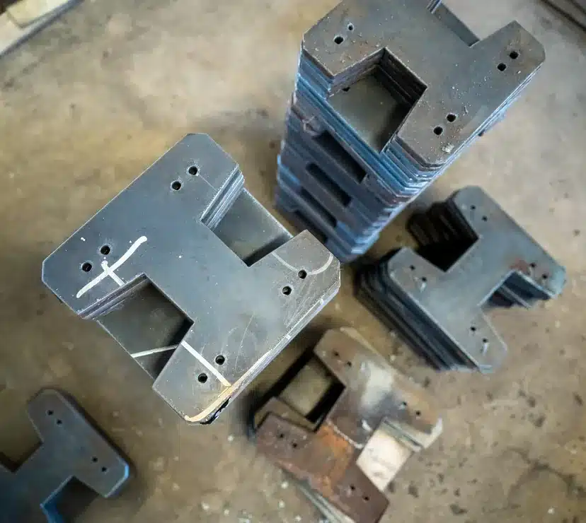 Laser-cut and formed steel prototype brackets on a shop floor in Illinois