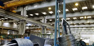 Overhead crane moving steel wire coils in a material handling facility in Illinois